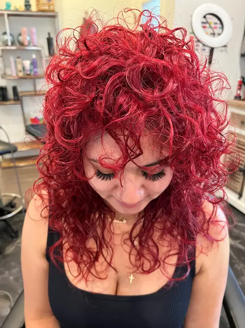 A shaggy curly wolf cut paired with cherry cola red brings texture, wild movement, and playful rock-(..)